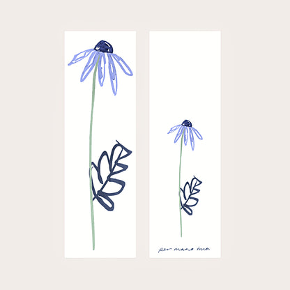 Back and front of a blue daisy bookmark, displayed side-by-side on a light pink background.