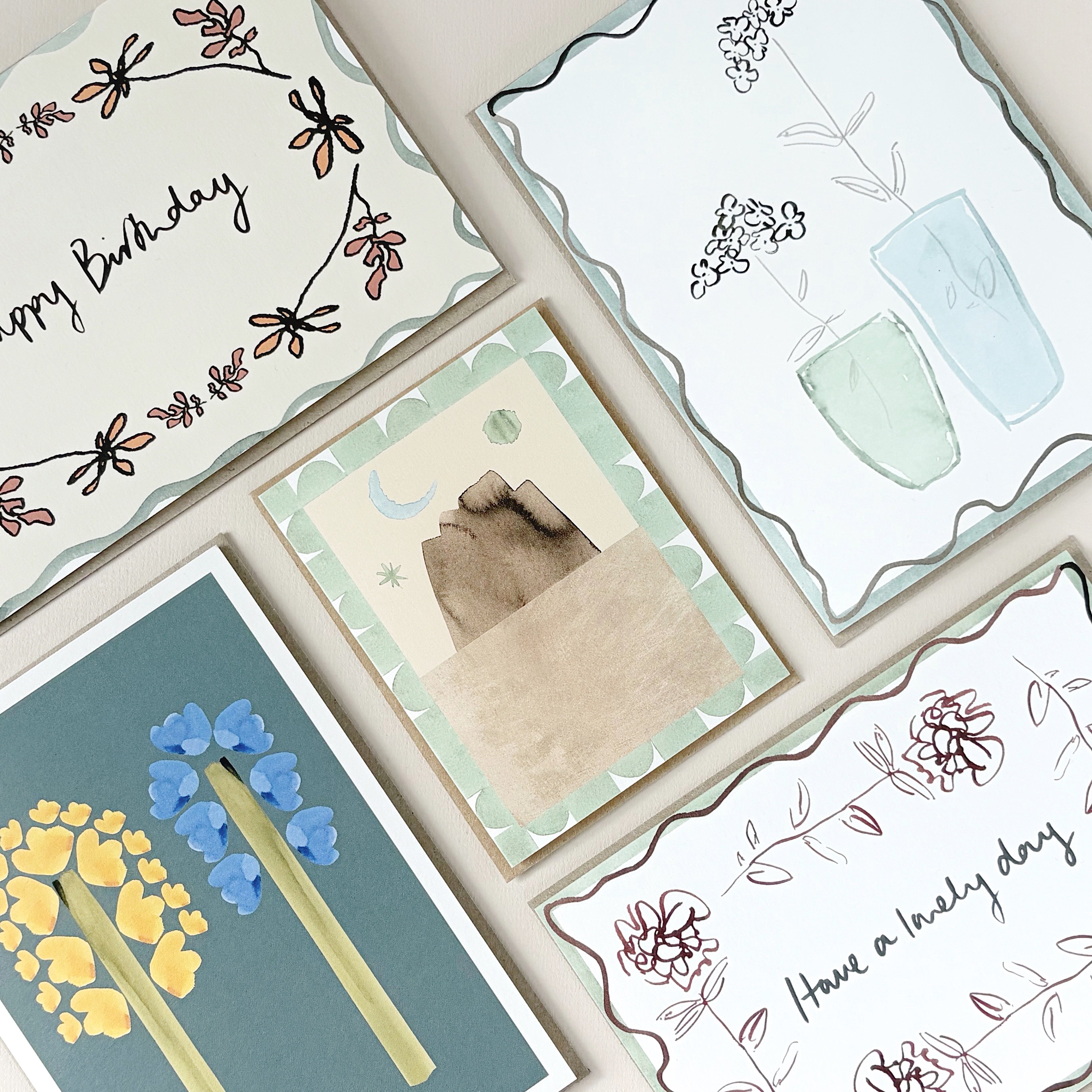 A collection of 5 hand-designed greeting cards with floral, birthday and art illustrations in soft neutral tones