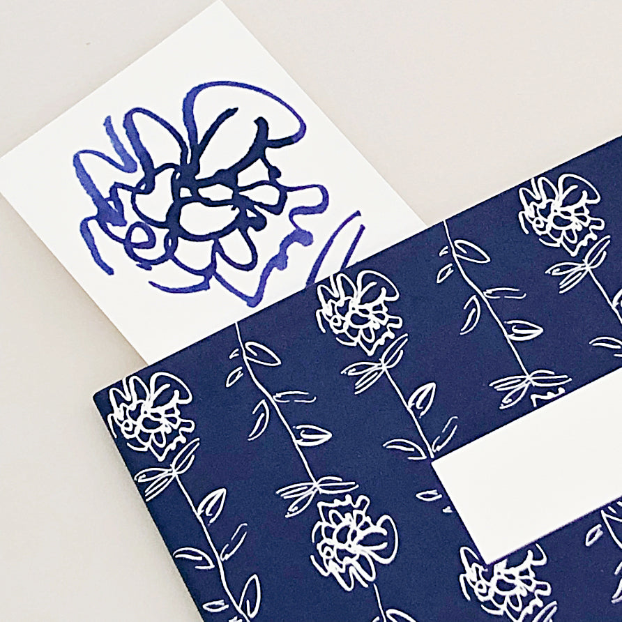 hand-designed floral bookmark peeking out from the top of a notebook